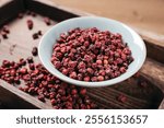 Sichuan peppercorns in bowls on retro wooden boards