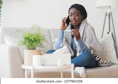 Sick African American Girl Sitting On Couch, Holding Thermometer And Calling Family Doctor For Counseling, Free Space