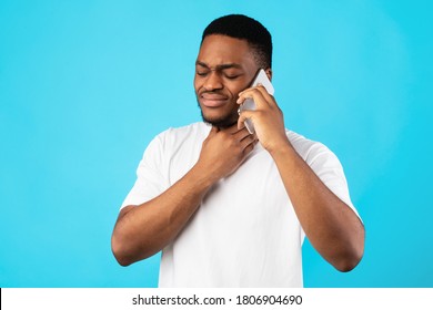 Sick African American Man Having Sore Throat Calling Doctor Standing Over Blue Studio Background. Cold And Flu Symptoms