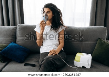 Sick african american woman with an inhaler. Unhealthy african american girl doing inhalation using nebulizer and inhaler for the treatment cough and flu