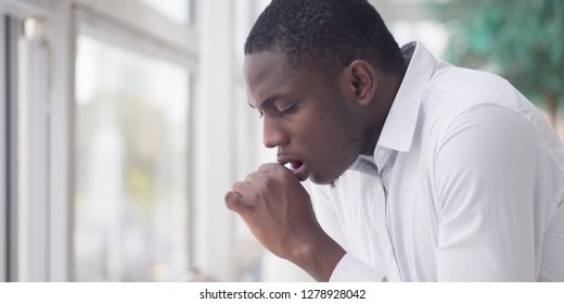 Sick African Man Coughing; Portrait Of Ill Black Man Cough Due To Cold, Flu, Allergy, Polluted Air, Fine Dust, Tuberculosis; Air Pollution, Lung Cancer, Emphysema Concept; African Man Model