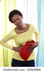 Sick African Woman With Hot Bottle And Stomach Pain