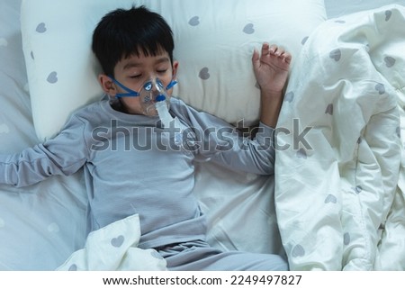Sick Asian child boy Respiratory syncytial virus (RSV) wears a pediatric ventilator lying in bed at home. health and medical