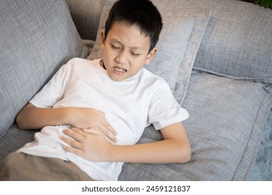 Sick asian child boy suffering from Gastritis,Gastric ulcer,stomach ache,inflammation of the stomach and intestines,symptoms of Gastroenteritis,infection of bacterial or viral,soreness,pain in abdomen - Powered by Shutterstock