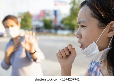 Sick Asian Child Girl With Fever And Dry Cough,woman Opened A Protective Mask While Coughing,spreading Flu,cold,Covid-19 Or Coronavirus,bad Etiquette,manners For Cough,sneeze Should Cover The Mask