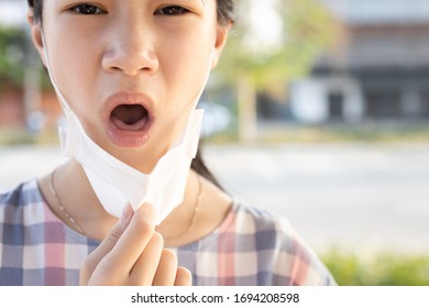 Sick Asian Child Girl With Fever And Dry Cough,woman Opened A Protective Mask While Coughing,spreading Flu,cold,Covid-19 Or Coronavirus,bad Etiquette,manners For Cough,sneeze Should Cover The Mask