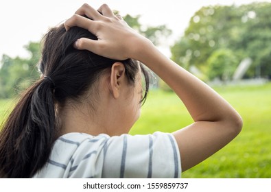 Sick Asian Child Girl Holding Her Painful Head, Brain Cancer,hemorrhagic Stroke And Tumor Inside Brain,female Teenage Person With A Severe Headache In Outdoor Park,health Problem, Health Care Concept