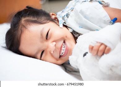 Sick Asian Child Girl Is Lay Down On The Bed And Smiling When She Feel Better In The Hospital