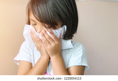 Sick Asian Little Child Girl Wiping And Cleaning Nose With Tissue On Her Hand. Common Cold Concept.