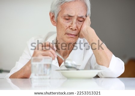Sick asian senior woman suffering from anorexia,bored with meal,eating less food,discomfort in swallowing,disease of Dysphagia,Old elderly patient with Anorexia-Cachexia syndrome,lack of appetite