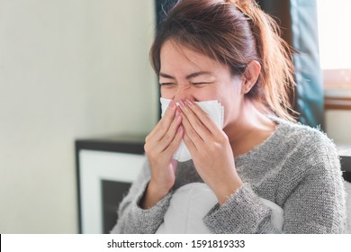 Sick asian woman have hight fever flu and sneezing into tissue on bed in bedroom, Medical and health concept, Selective focus.