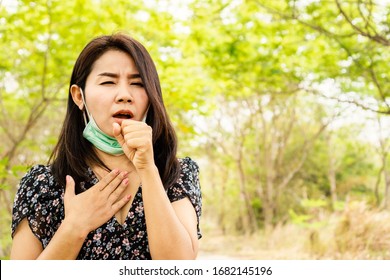 Sick Asian Woman Wearing Face Mask Got Covid 19 Virus Having Sore Throat, Pain Chest And Coughing Outdoors  