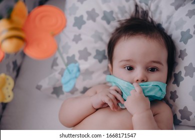 Sick Baby With A Mask On His Face Laying In His Bed. Mother Checks The Temperature Of A Sick Baby.