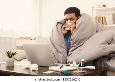 Sick Black Student Working From Home On Laptop With Homework Assignment Or University Project, Wrapped Under Blanket On Couch, Free Space