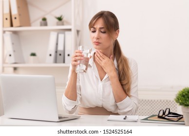 Sick Business Lady Having Sore Throat Holding Glass Of Water, Working At Laptop In Modern Office. Selective Focus - Powered by Shutterstock