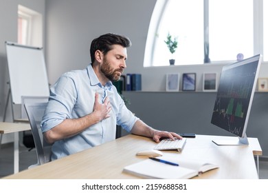 Sick businessman working in the office, man worried and holding his hand to his chest, severe heart pain - Shutterstock ID 2159688581