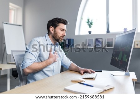 Sick businessman working in the office, man worried and holding his hand to his chest, severe heart pain