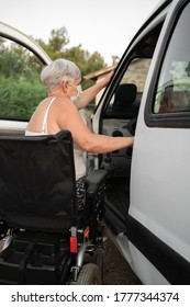 Sick Caucasian Older Woman In A Wheelchair Getting Into The Car