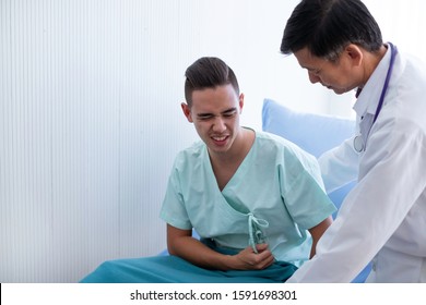 Sick Caucasian Patient Having Stomach Pain With Asian Doctor Taking Care In Hospital. Sick Patient Will Pay For Medical Fee By Healthcare Insurance. Doctor And Patient & Healthcare Insurance Concept.