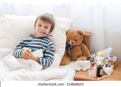 Sick Child Boy Lying In Bed With A Fever, Resting At Home