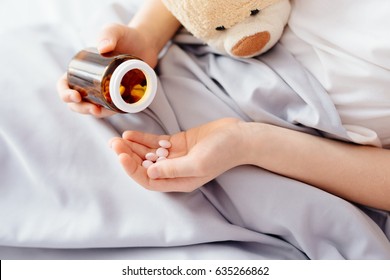 Sick Child Boy Takes Medication In Bed. Kid's Clinic.