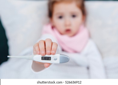 Sick Child Showing Her High Temperature In A Bed