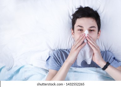 A Sick Child Is A Teenager In Bed, View From Above, In The Hands The Handkerchief