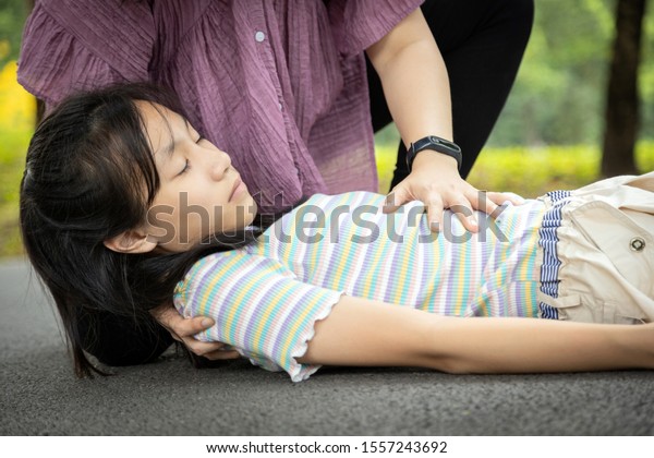 Sick daughter is fainted and fallen on floor while\
playing and exercise,asian mother help,take care, child girl with\
congestive heart failure,female unconscious fell to the ground\
suffer heart attack