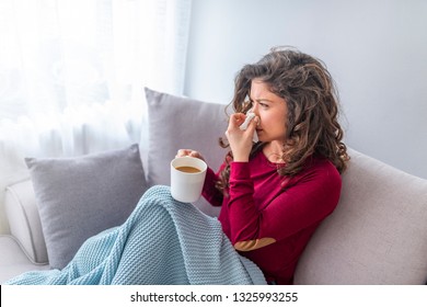 Sick day at home. Asian woman has runny and common cold. Cough. Closeup Of Beautiful Young Woman Caught Cold Or Flu Illness. Portrait Of Unhealthy Girl In Scarf Feeling Pain In Throat. - Shutterstock ID 1325993255
