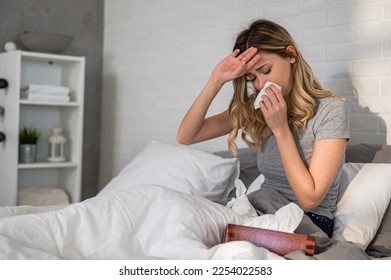 Sick day at home. Woman has runny and common cold. Cough. Closeup Of Beautiful Young Woman Caught Cold Or Flu Illness. Portrait Of Unhealthy Girl In Feeling Pain In Throat. - Powered by Shutterstock