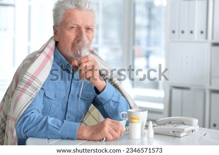 Sick elderly man makes inhalation. High quality photo