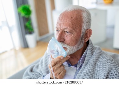 Sick elderly man making inhalation, medicine is the best medicine. Ill senior man wearing an oxygen mask and undergoing treatment for covid-19. Senior man with an inhaler