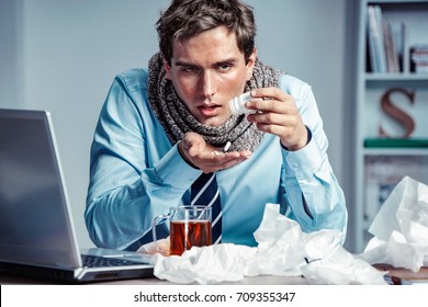 Sick Employee Takes Pills For Flu In The Office. Photo Of Young Man Suffering Virus Of Flu.