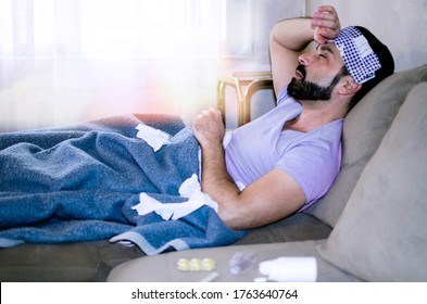 Sick Exhausted Man Laying On Sofa Having High Temperature And Fever