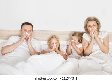 Sick Family Lying In Bed At Home