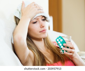 Sick girl with glass of water taking medicine - Powered by Shutterstock