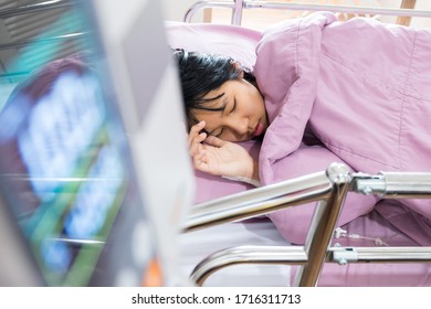 A Sick Girl In A Purple Striped Suit With Life Support Equipment On A Hospital Bed