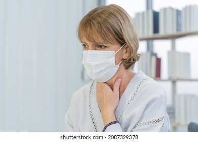 Sick, Hurt Or Pain, Weakness Caucasian Mature Adult, Senior Woman Wearing Mask With Sore Throat, Headache Have Fever, Flu Or Weakness, Sitting On Sofa Bed At Home. Health Care Person On Virus Seasonal