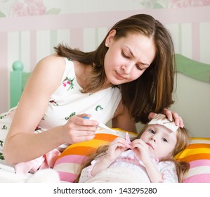 Sick Kid With High Fever Laying In Bed And Mother Taking Temperature