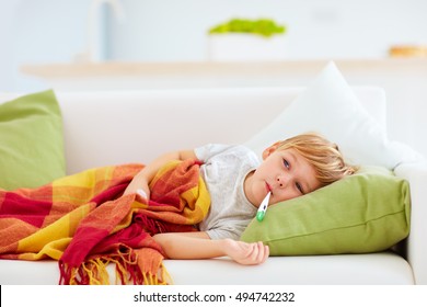 Sick Kid With Runny Nose And Fever Heat Lying On Couch At Home