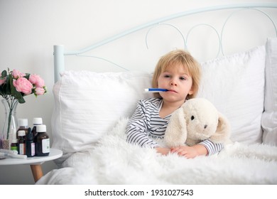 Sick Little Blond Toddler Boy, Lying In Bed With Fever, Hugging Little Fluffy Toy, Medicine Next To Him On The Night Stand