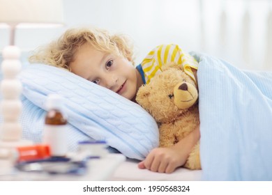 Sick little boy with asthma medicine. Ill child lying in bed. Unwell kid with chamber inhaler for cough treatment. Flu season. Bedroom or hospital room for young patient. Healthcare and medication. - Shutterstock ID 1950568324