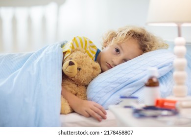 Sick little boy with asthma medicine. Ill child lying in bed. Unwell kid with chamber inhaler for cough treatment. Flu season. Bedroom or hospital room for young patient. Healthcare and medication. - Shutterstock ID 2178458807