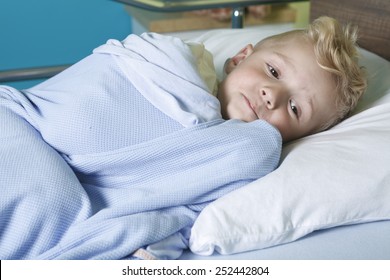 A Sick Little Boy In A Hospital Bed