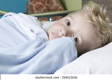 A Sick Little Boy In A Hospital Bed