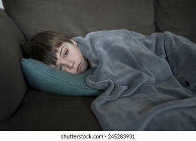 Sick Little Boy Laying On The Sofa