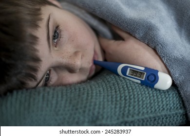 Sick Little Boy With Thermometer In His Mouth