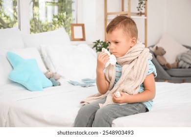 Sick little boy with tissue sneezing in bedroom - Powered by Shutterstock