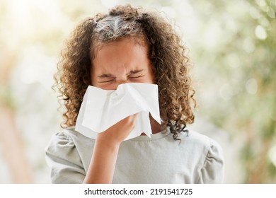 Sick Little Girl With A Flu, Blowing Her Nose And Looking Uncomfortable. Child Suffering With Sinus, Allergies Or Covid Symptoms And Feeling Unwell. Kid With A Cold Sneezing And Holding A Tissue