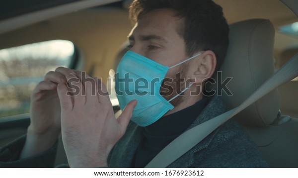 Sick man gets in\
the car coughs sneeze wearing Protective Face Mask COVID-19\
coronavirus infection pandemic disease virus male tourist epidemic\
air health illness slow\
motion